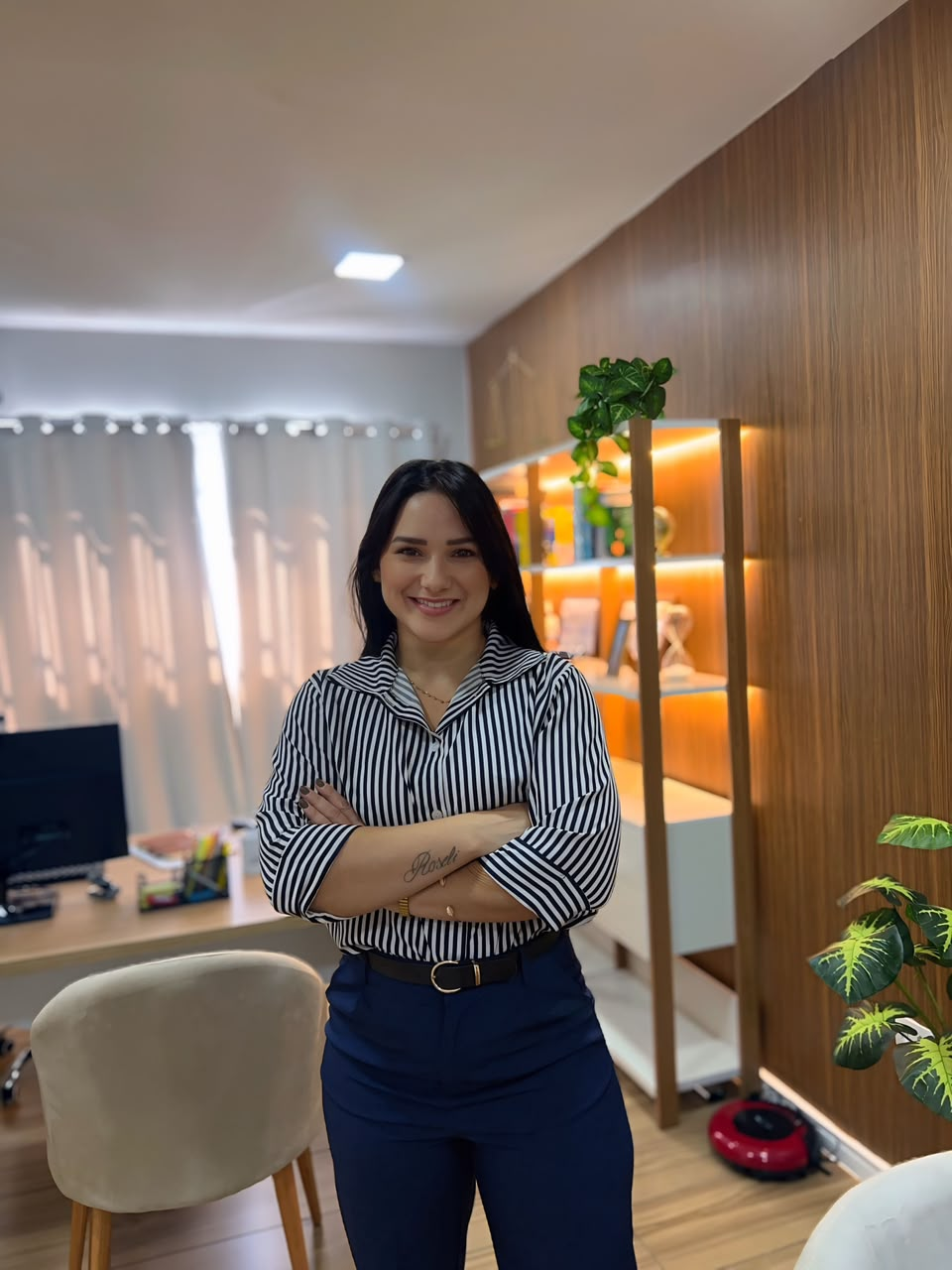 Caroline Mak, advogada, em pé no escritório com os braços cruzados